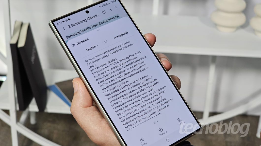 Mão segurando smartphone, exibindo tradução de texto