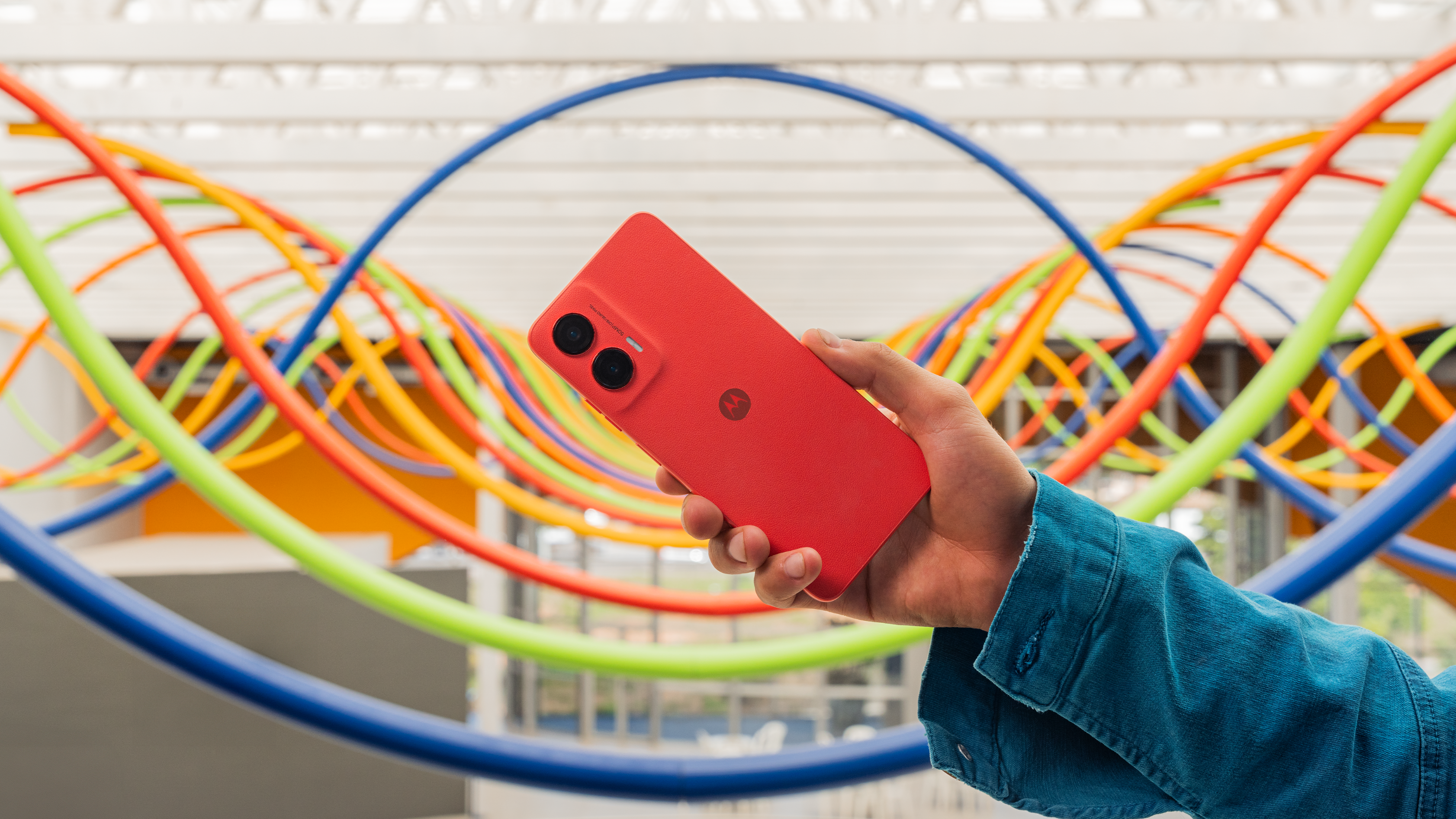 Smartphone Moto G35 vermelho nas mãos de uma pessoa