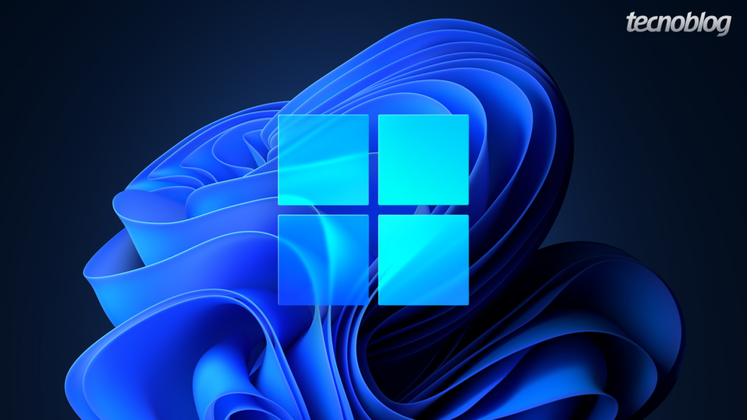 Imagem digital de fundo que mescla tons de azul escuro e marinho. No centro, sobreposto a um padrão abstrato de ondas ou tecido em relevo, está o logotipo do sistema operacional Windows 11: um quadrado formado por quatro janelas quadradas de cor azul-clara luminosa. O logo do "Tecnoblog" aparece no canto superior direito.