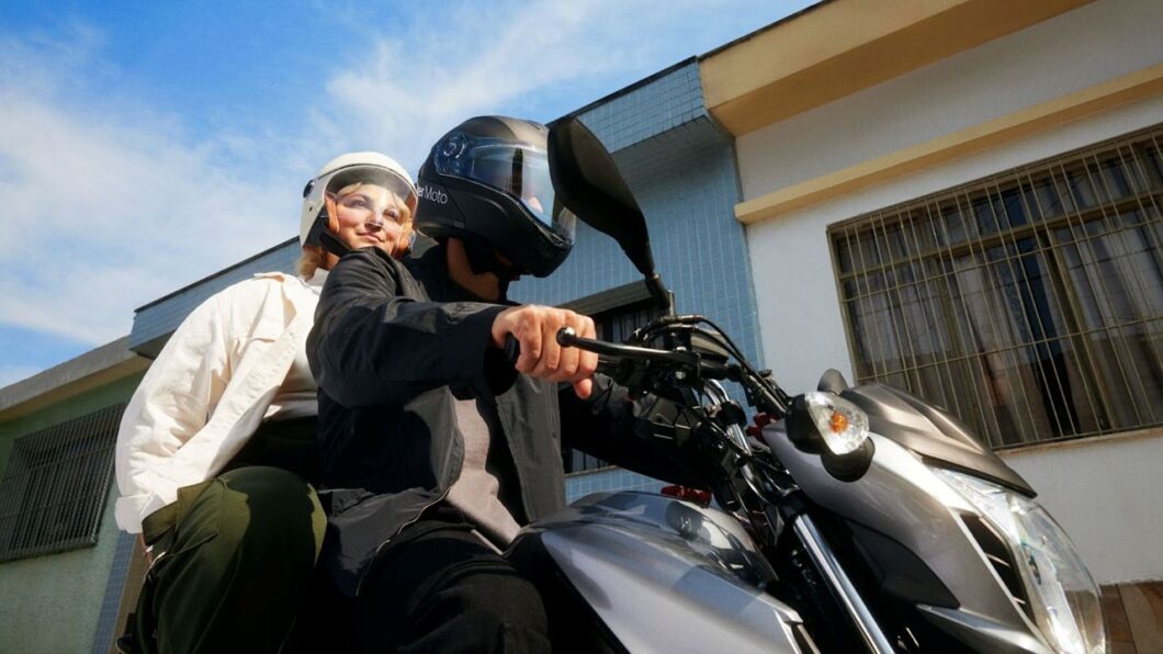 Passageira e piloto em uma moto do servi&ccedil;o Uber Moto