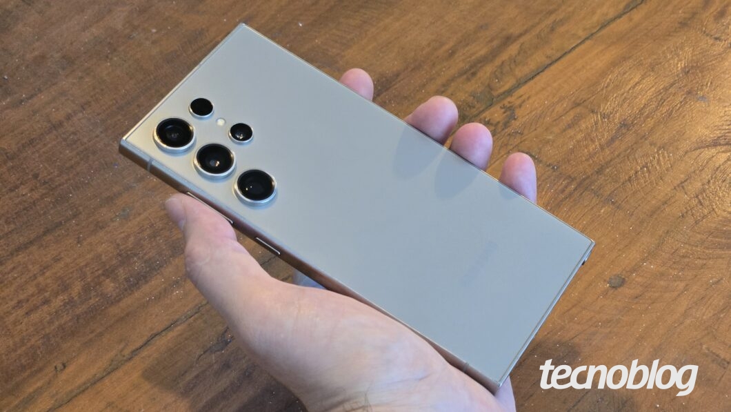 Mão segurando smartphone, visto de trás