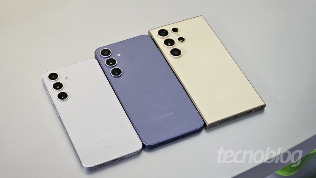 Três smartphones lado-a-lado, organizados na diagonal sobre uma mesa