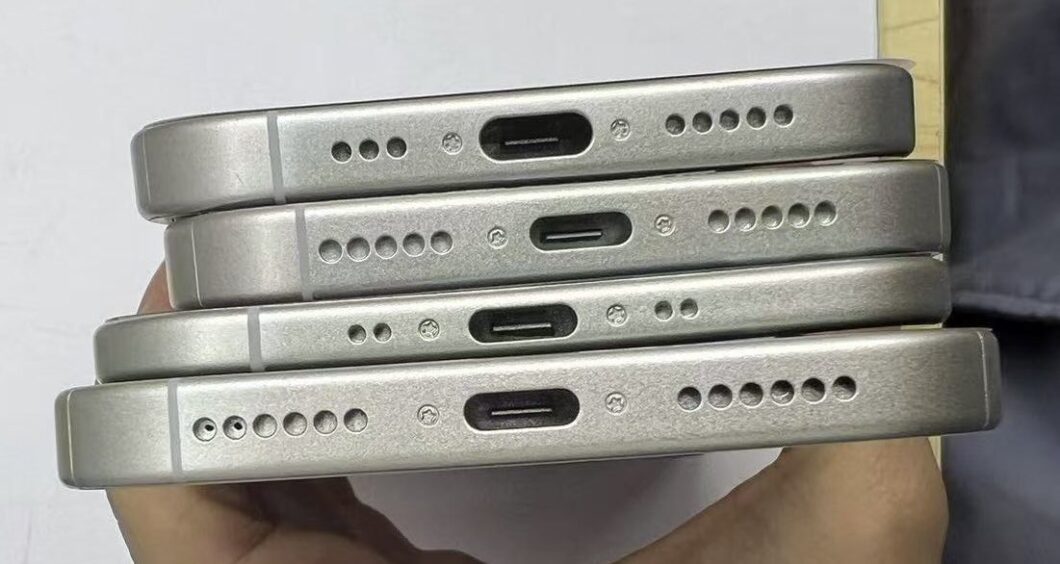 Quatro peças de telefone celular cinzento-prateado empilhadas umas sobre as outras. A imagem mostra as costas dos telefones, destacando as perfurações e os slots de entrada.