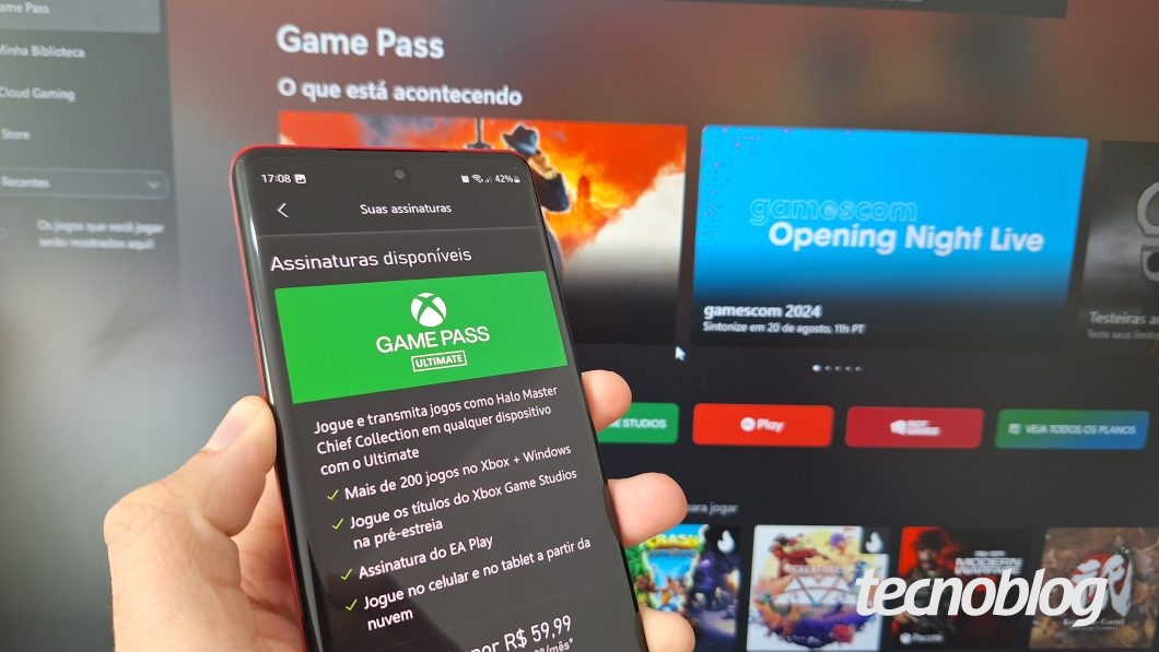 Uma mão segura um celular com aplicativo Xbox Game Pass exibindo a página Suas Assinaturas