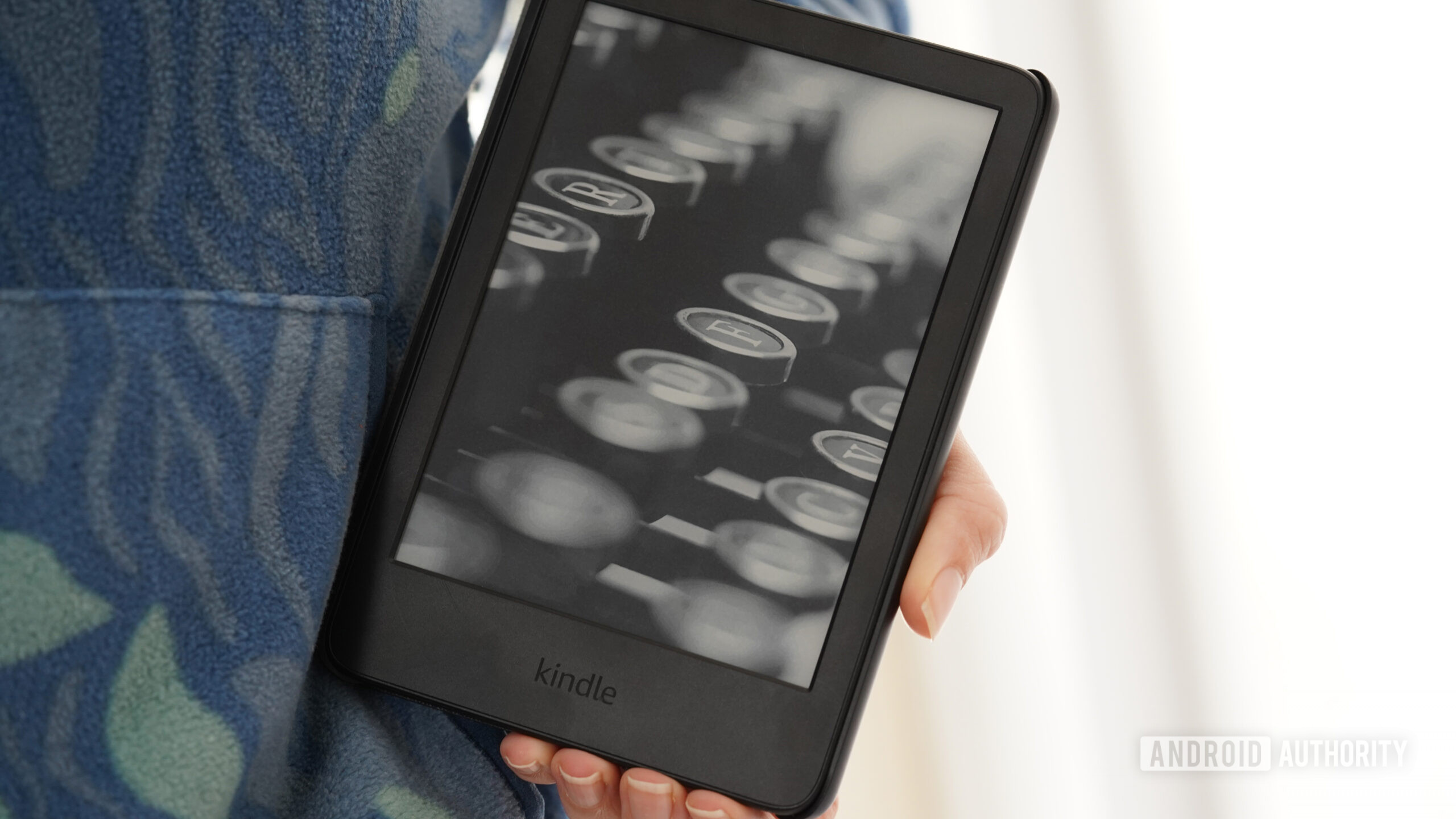 Um usuário segura um Kindle 2024 contra um moletom estampado.