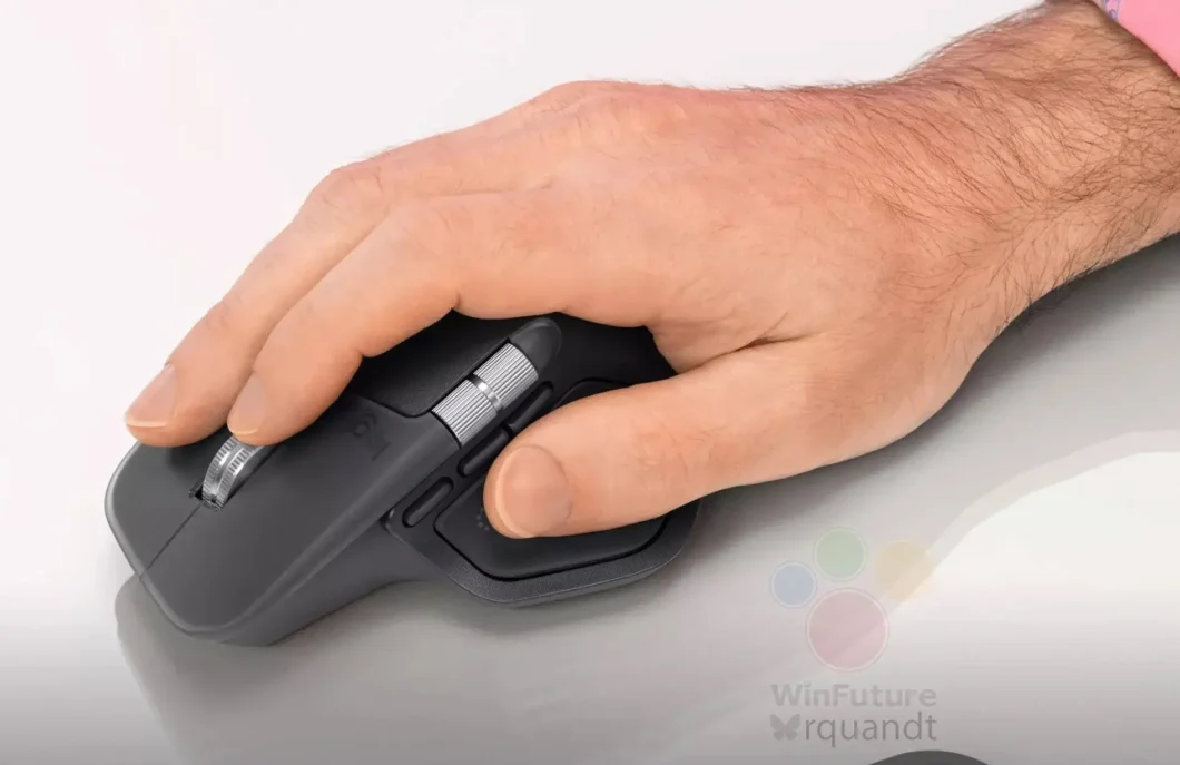 Um close da mão de uma pessoa segurando um mouse ergonômico preto Logitech. O mouse tem um apoio para o polegar e duas rodas de rolagem prateadas. O fundo é branco.