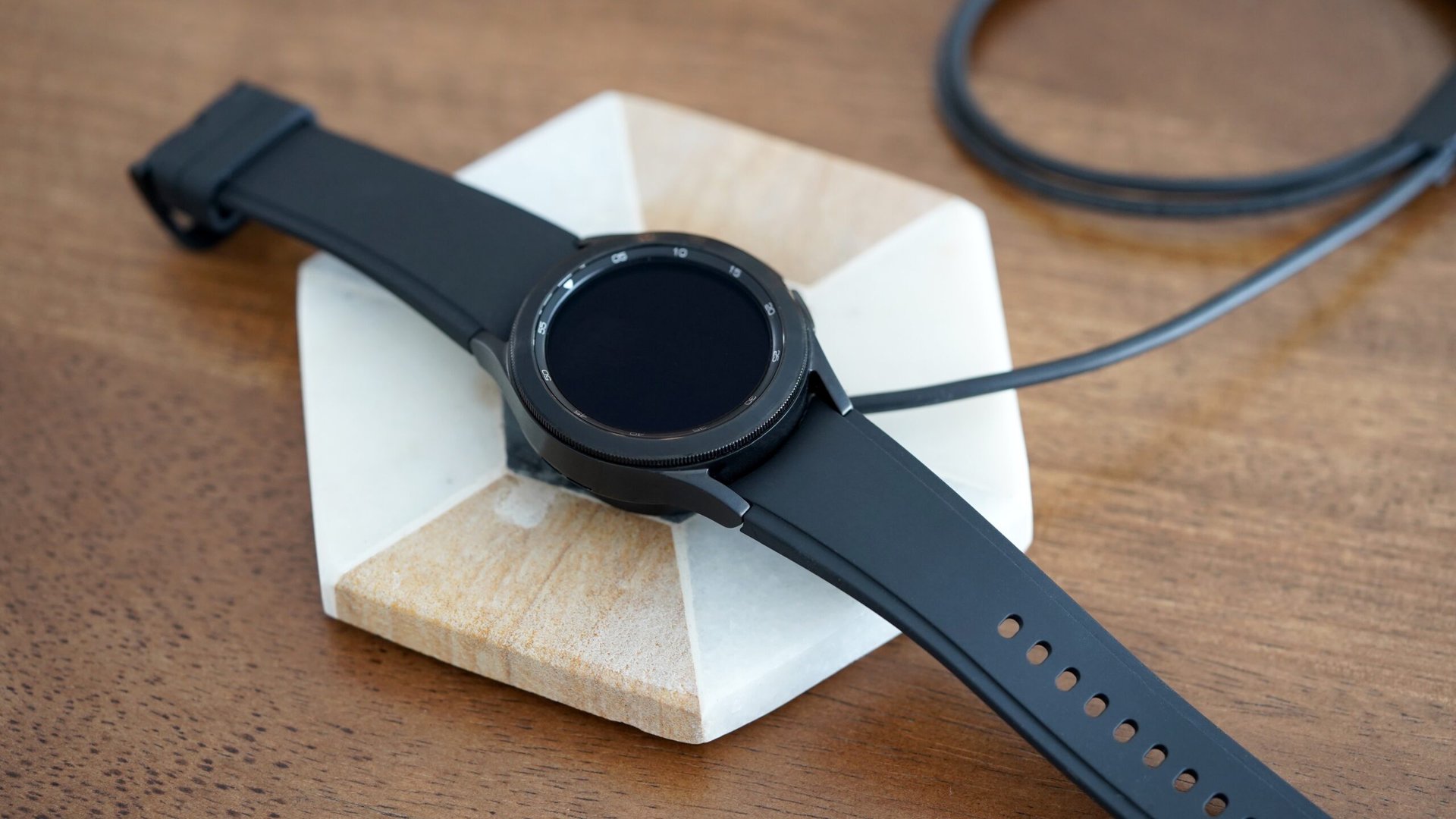 Samsung Galaxy Watch 4 no Classic Charger Um relógio Samsung Galaxy 4 repousa em seu carregador, mas não cobra.