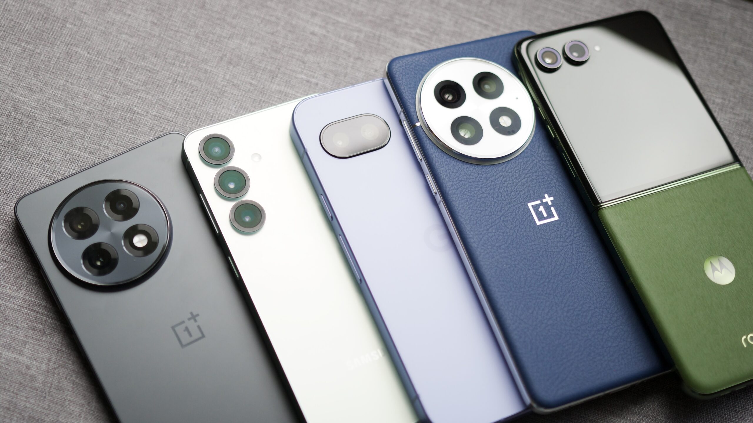 Telefones Android favoritos Prime Day 2025 1 Os OnePlus 13R, Galaxy S25, Pixel 9A, OnePlus 13 e Motorola Razr Plus (2024) estão deitados um ao lado do outro.