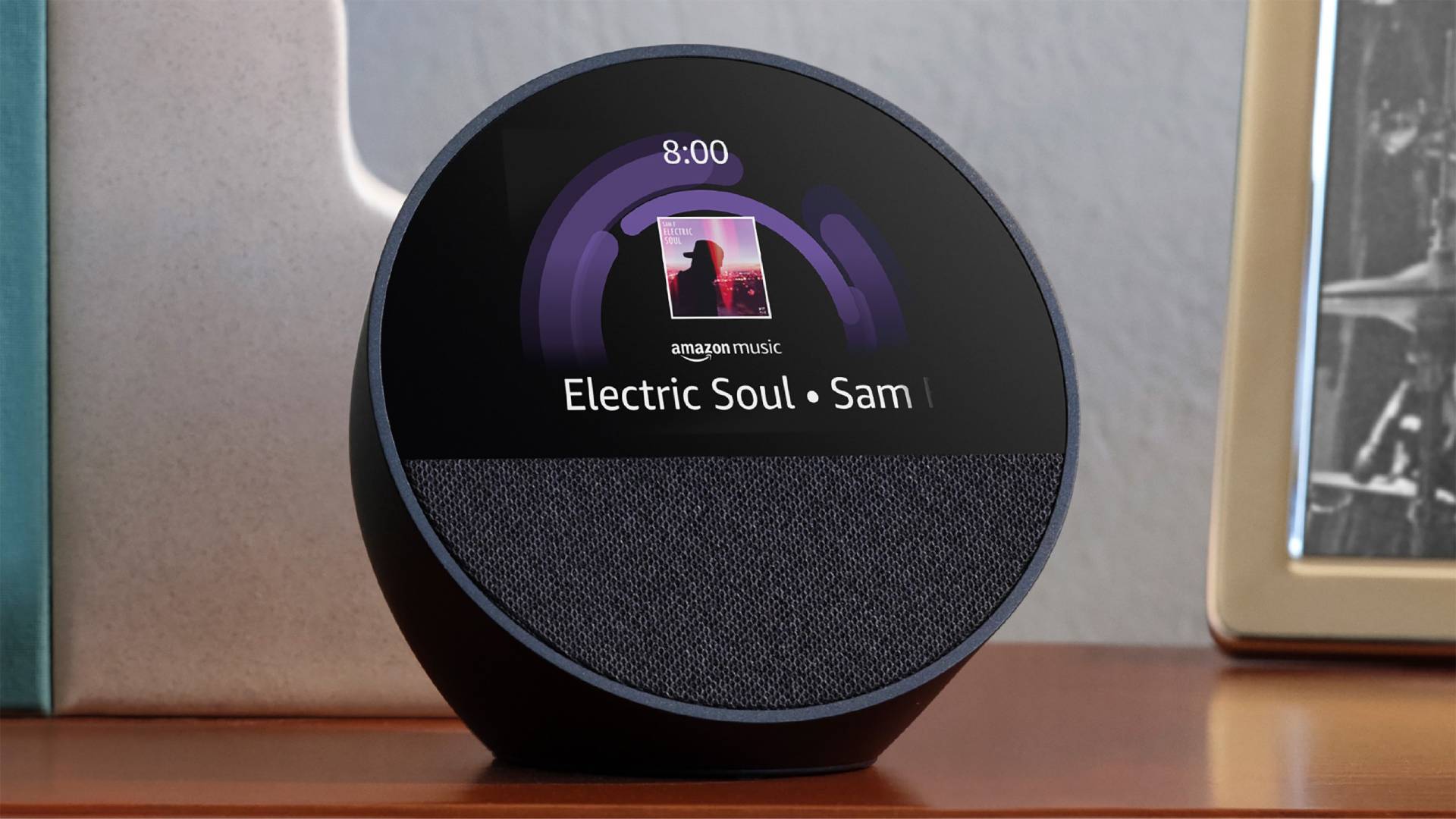 Imagem de estoque de eco (2024) Black Echo Spot (2024) colocado em uma mesa com arte do álbum e tempo na tela.