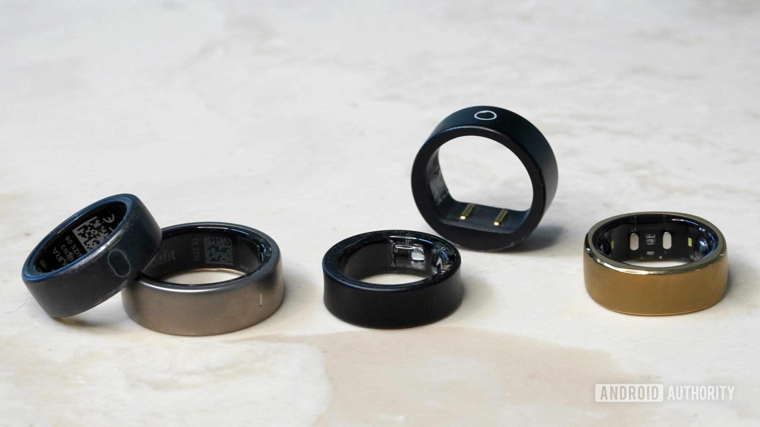 Variedade Smart Ring Uma variedade de anéis inteligentes repousa em uma superfície de mármore.