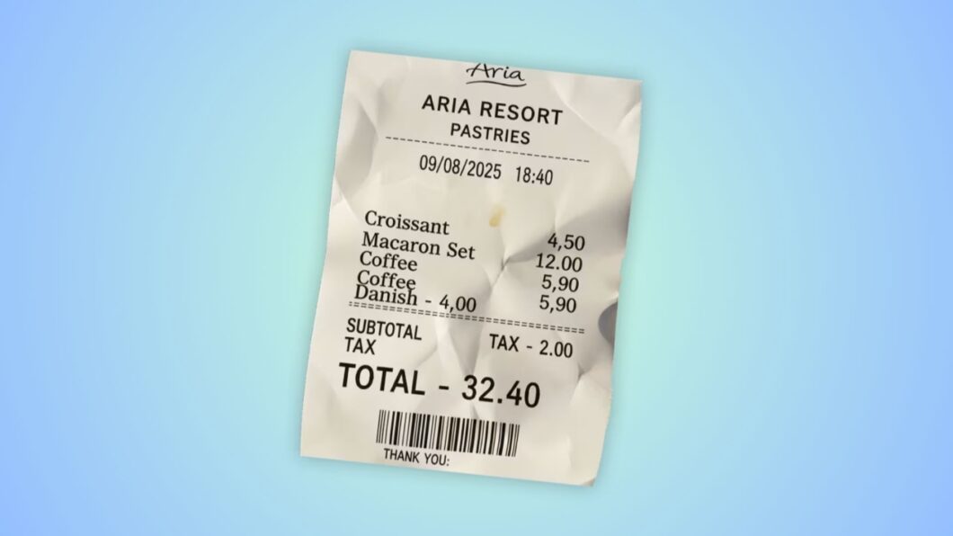 Foto de um recibo de papel de padaria, gerado por inteligência artificial, amassado e ligeiramente inclinado, sobre um fundo azul-claro com gradiente branco. No topo do recibo, é possível ler "Aria ARIA RESORT PASTRIES" e a data "09/08/2025 18:40".