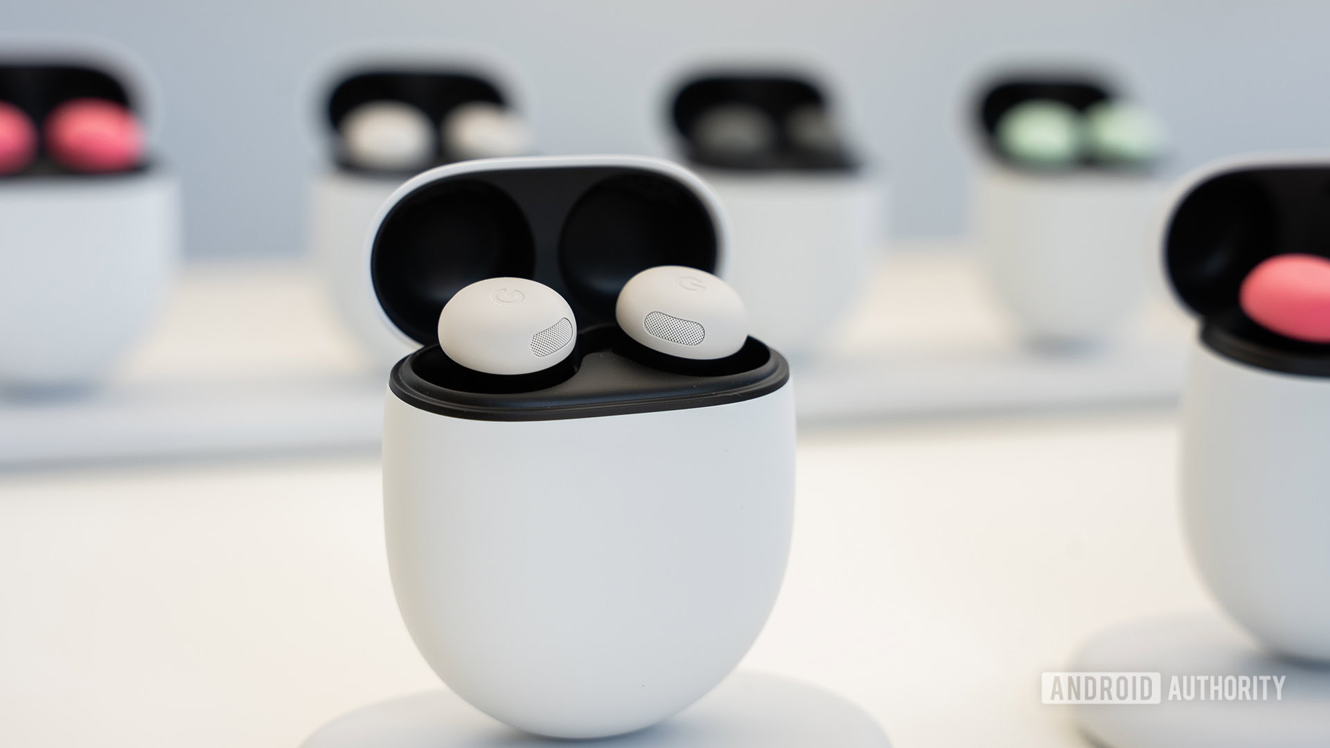 Google Pixel Buds Pro 2 em cor de porcelana em pé na posição vertical com outros casos Pixel Buds Pro 2