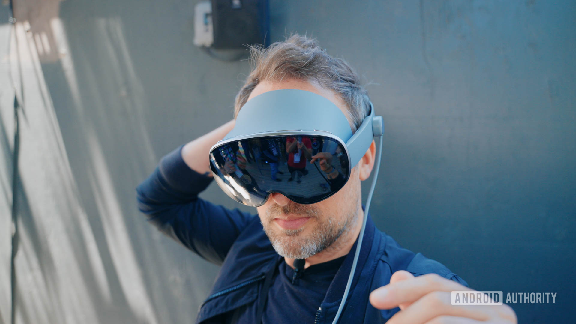 Fone de ouvido Google IO 2025 Project Moohan na cabeça do homem enquanto ele ajusta o ajuste