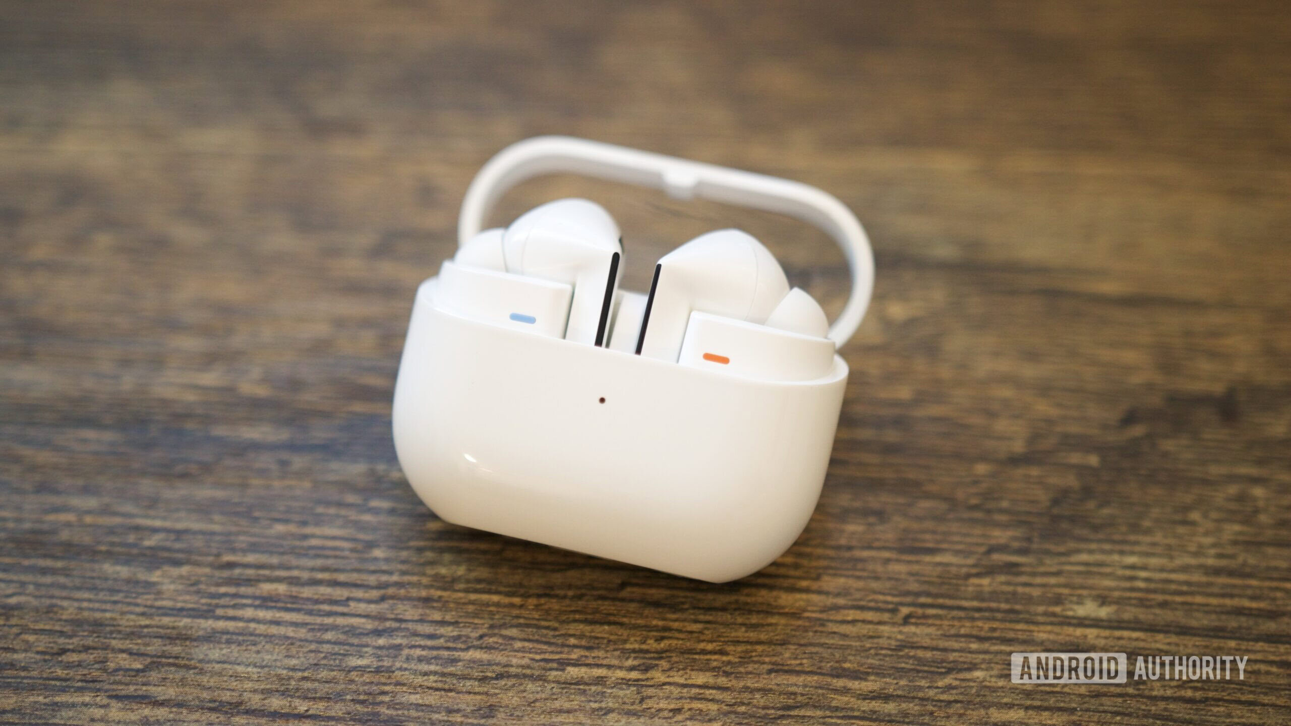 O Galaxy Buds 3 Pro em seu estojo de carregamento, apoiado em uma mesa.