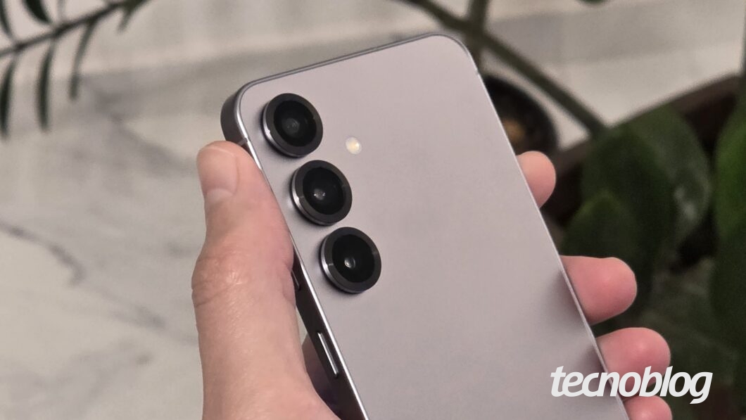 Mão segurando o Galaxy S25, mostrando a traseira com as câmeras