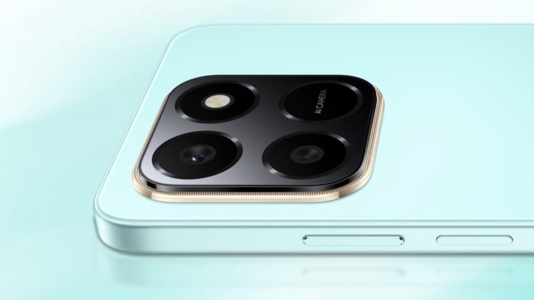 Close-up do módulo de câmera traseira de um smartphone Honor X7d na cor Azul/Verde Menta Claro. O módulo de câmera é quadrado e preto, com quatro lentes e um flash. O módulo é circundado por uma moldura de realce metálica na cor Dourado/Cobre.