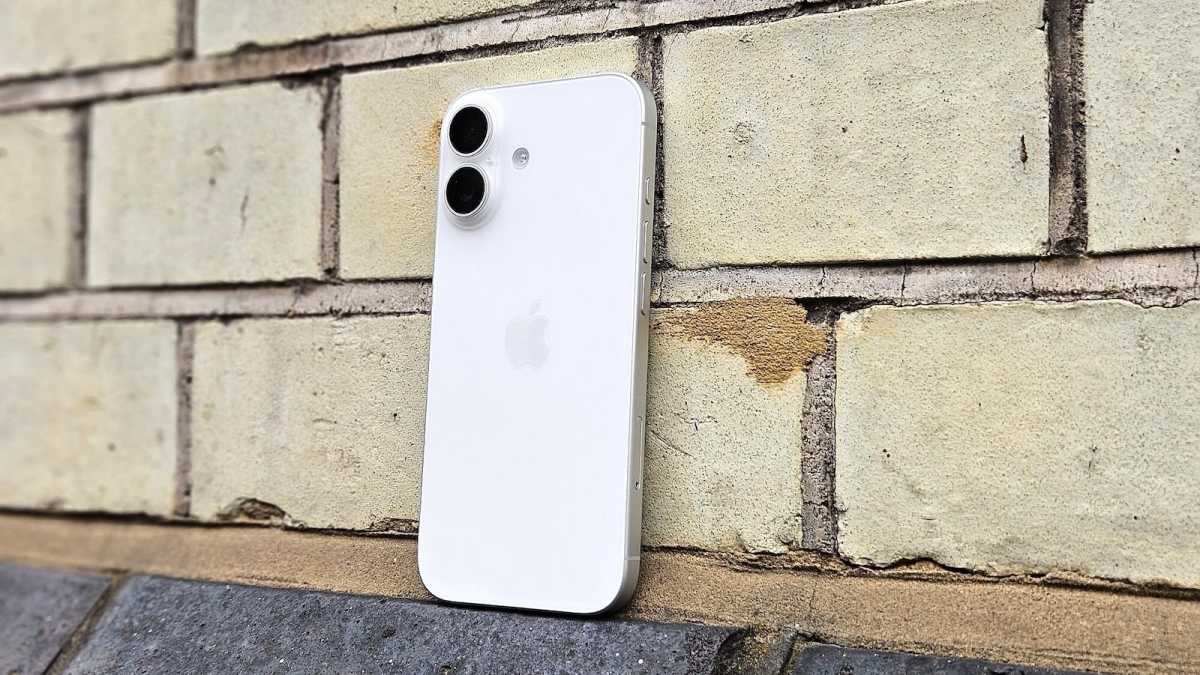 iPhone 17 in white, against a brick wall