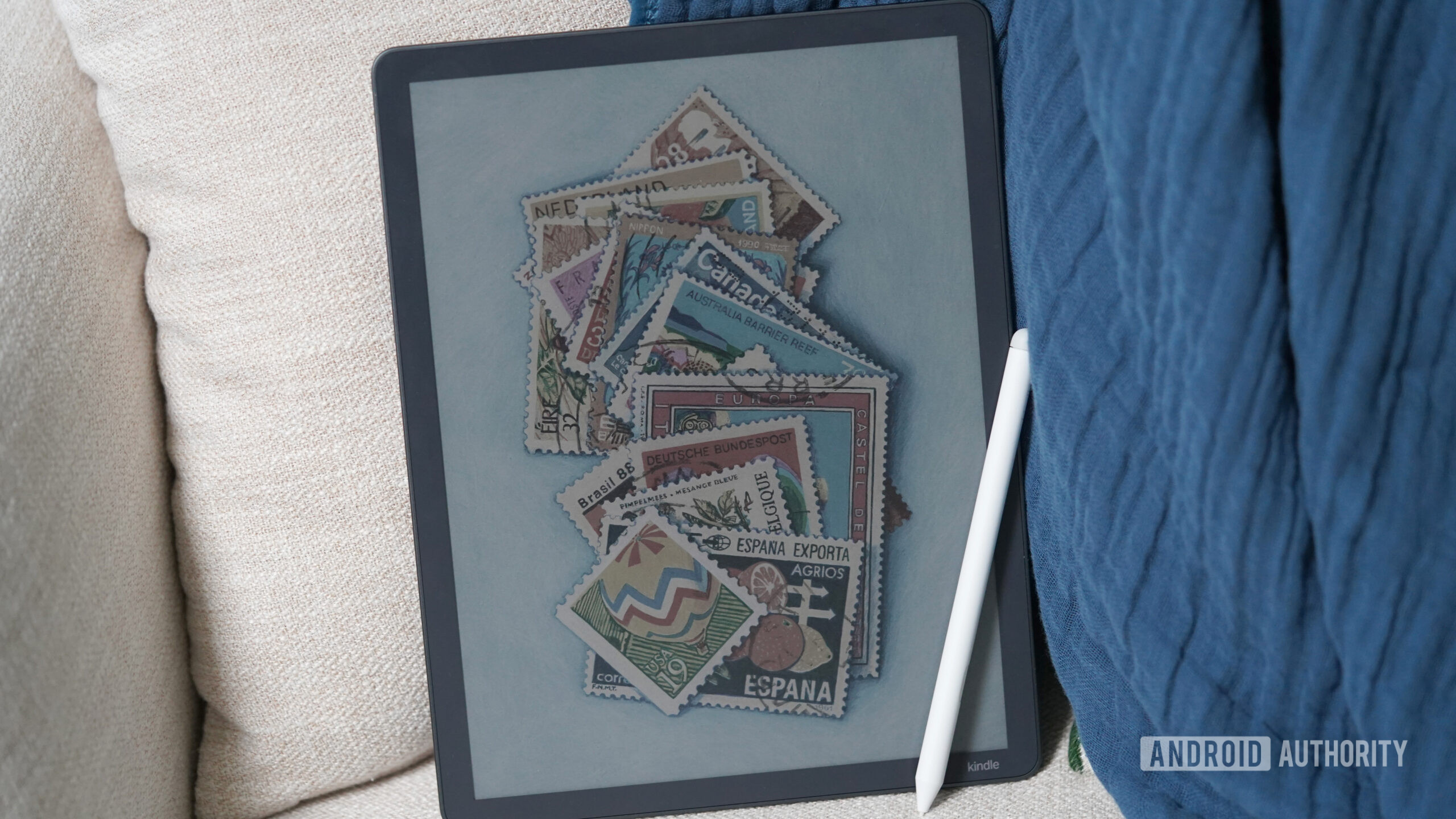 Um Kindle Scribe Colorsoft descansa em um sof&aacute;.