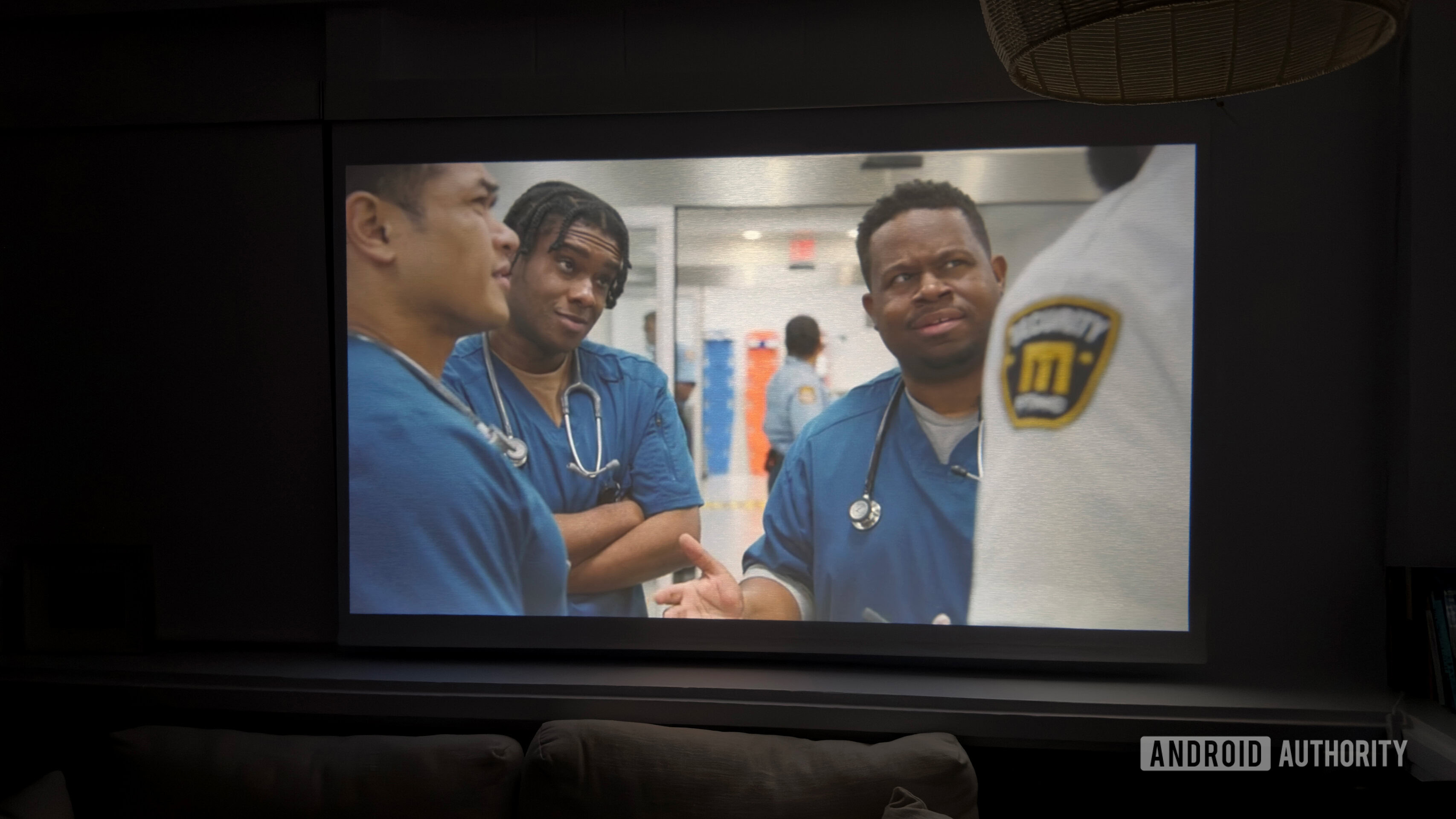 Um Aurzen Roku TV EAZZE D1R projeta uma cena de The Pitt.