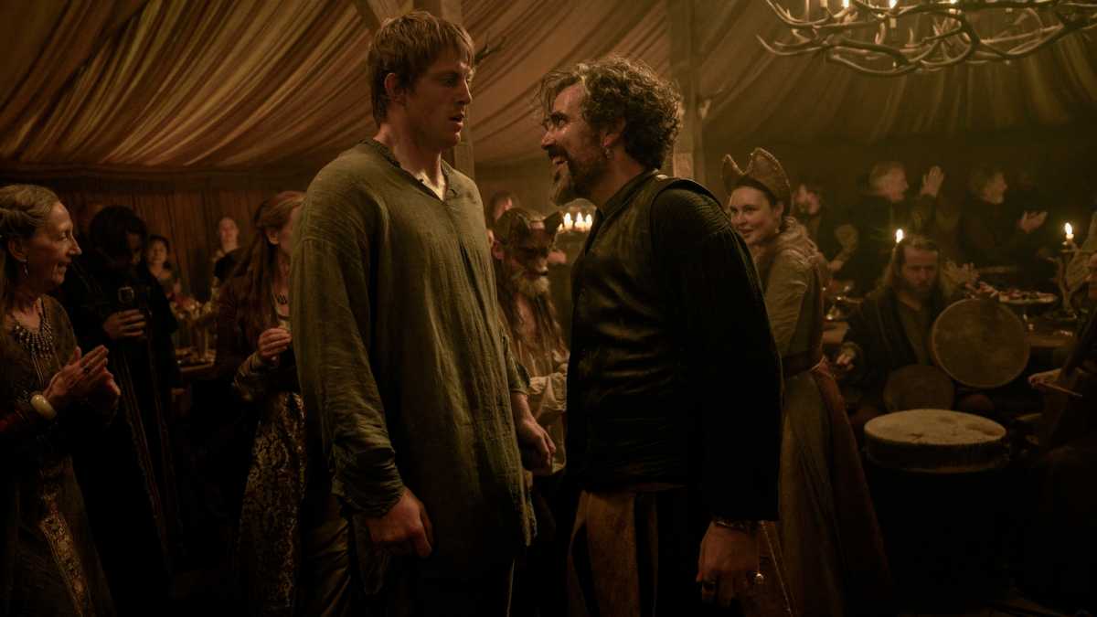 Two men stand face to face in a pavilion