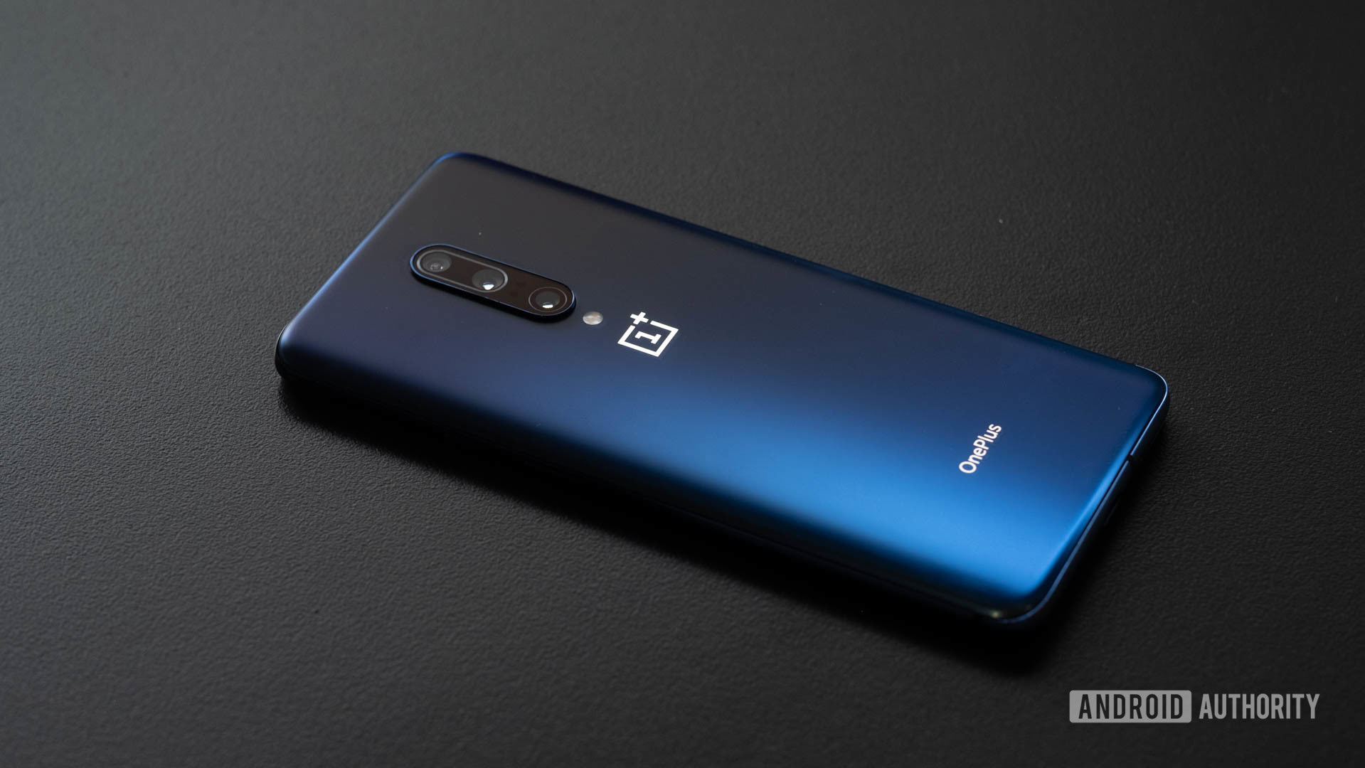 Telefone OnePlus 7 Pro inclinado na parte de tr&aacute;s da mesa