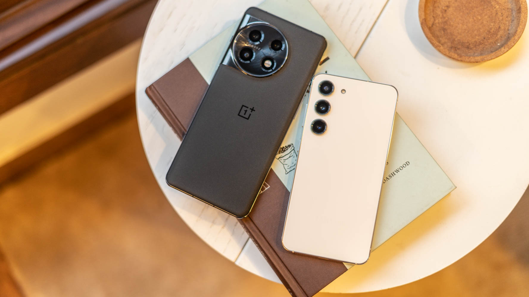 Pain&eacute;is traseiros OnePlus 11 vs Samsung Galaxy S23 colocados em um livro