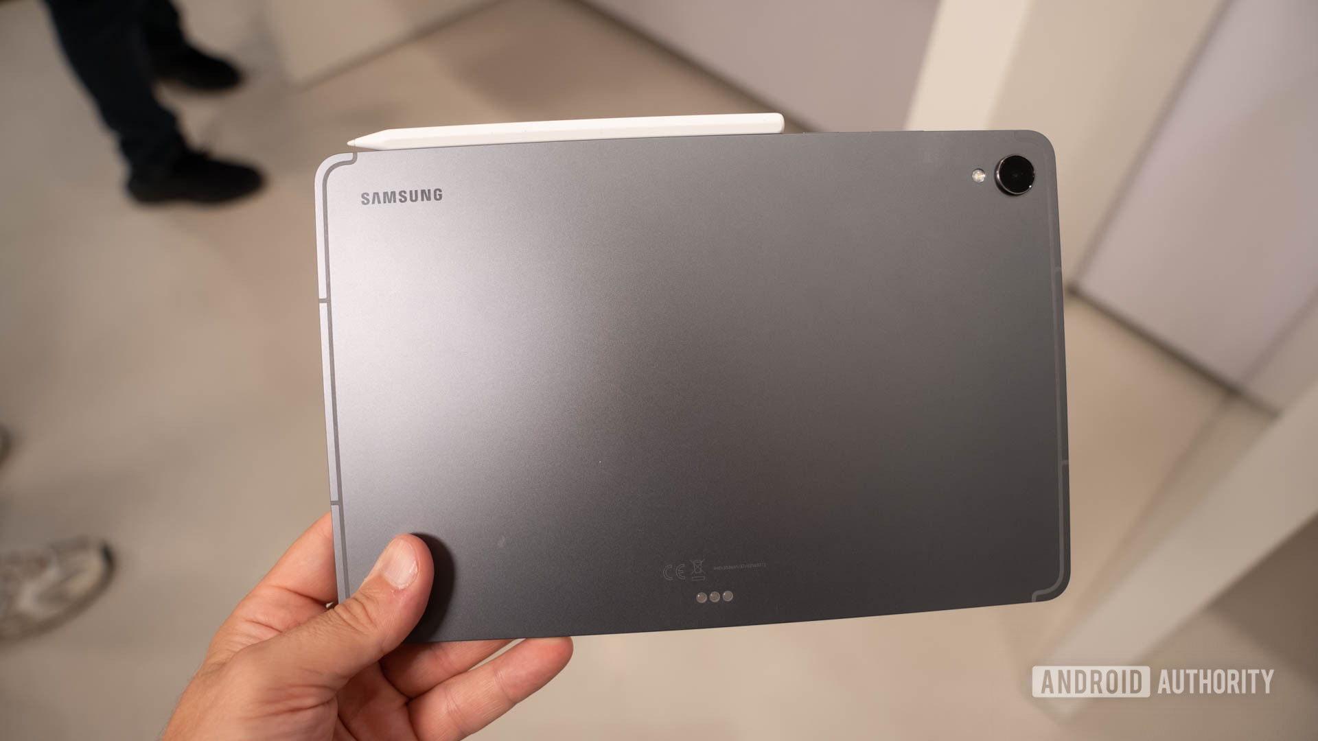 Samsung Galaxy Tab S11 na m&atilde;o do homem mostrando as costas