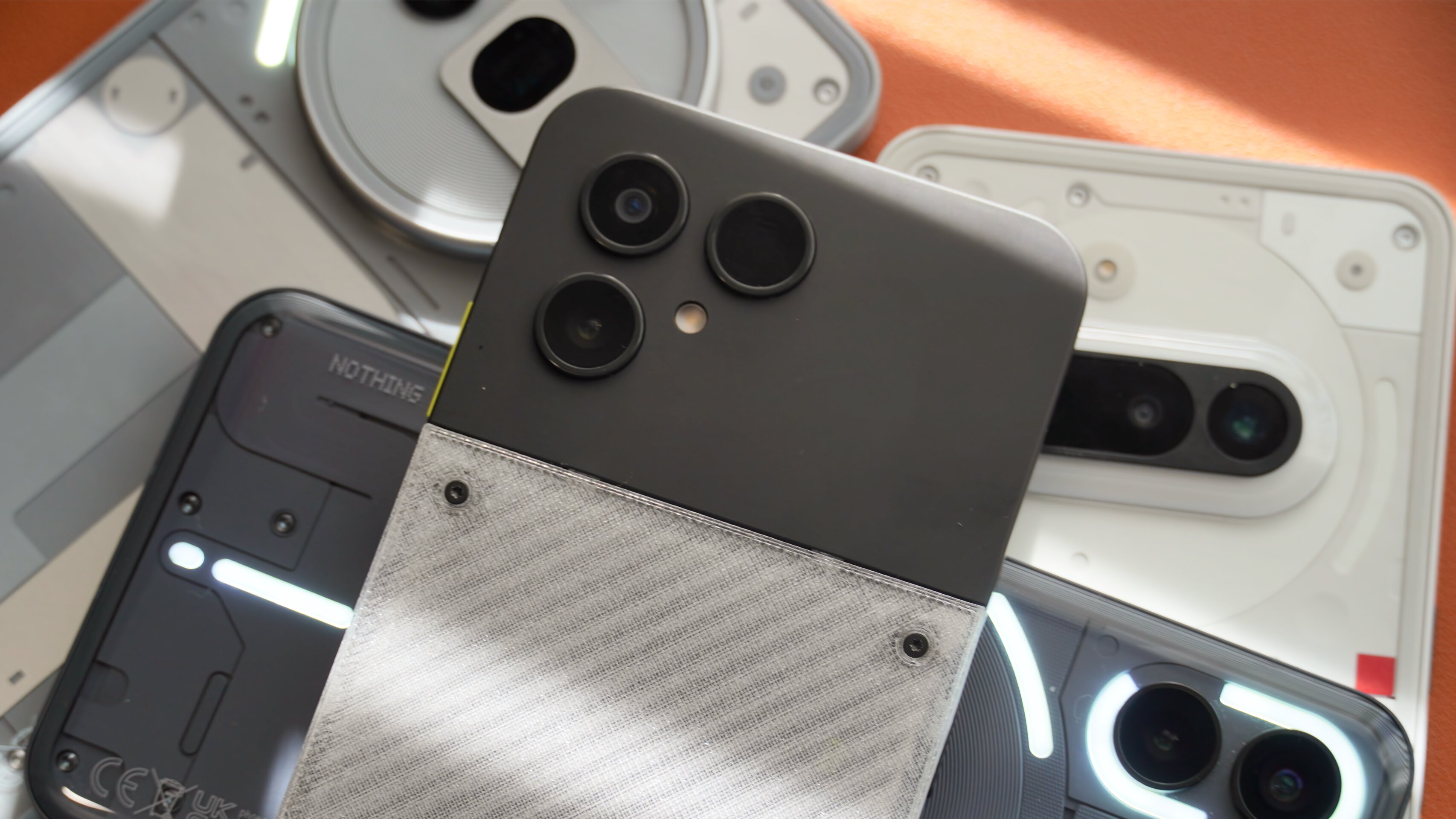 Comparação de telefone Fairphone 6 Nothing 1 Um close do Fairphone 6 em cima de vários telefones Nothing.