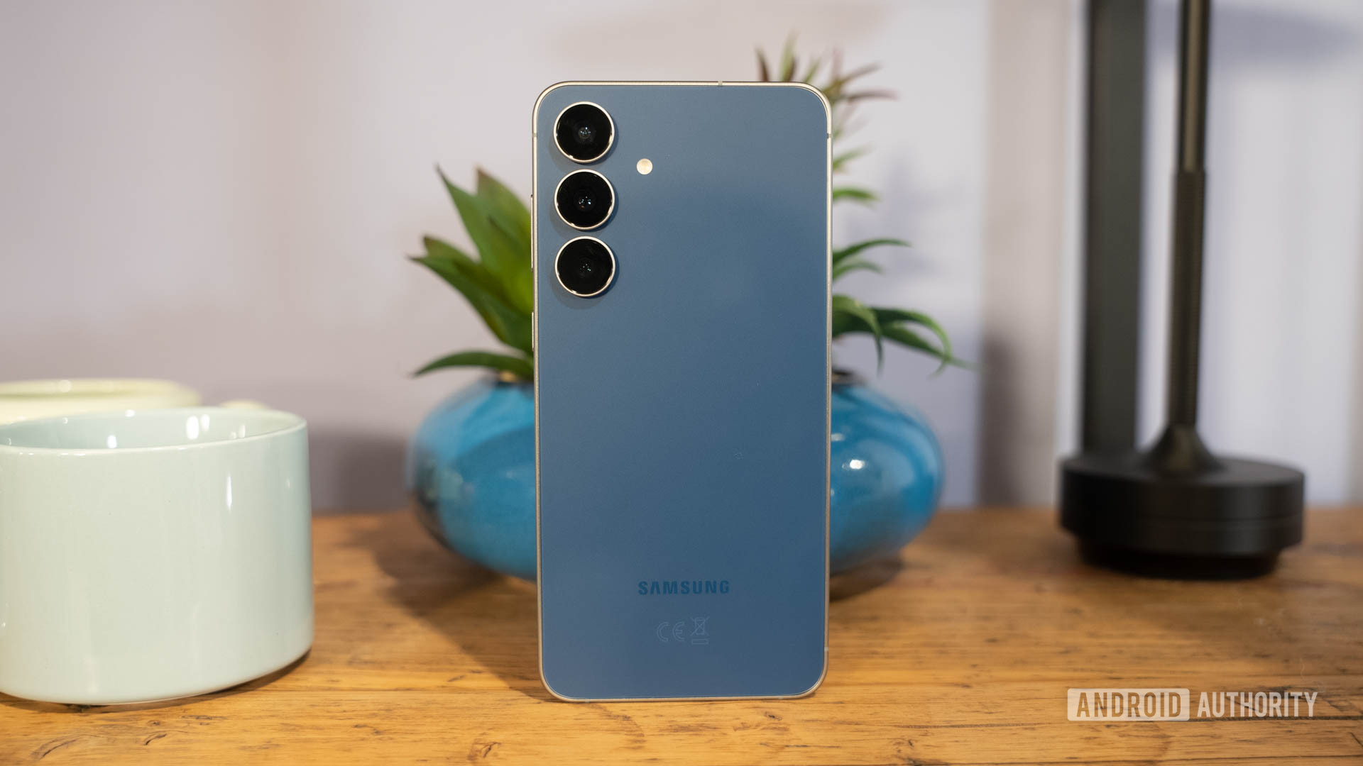 Samsung Galaxy S25 FE em Navy em frente à planta Samsung Galaxy S25 FE em Navy em frente à planta