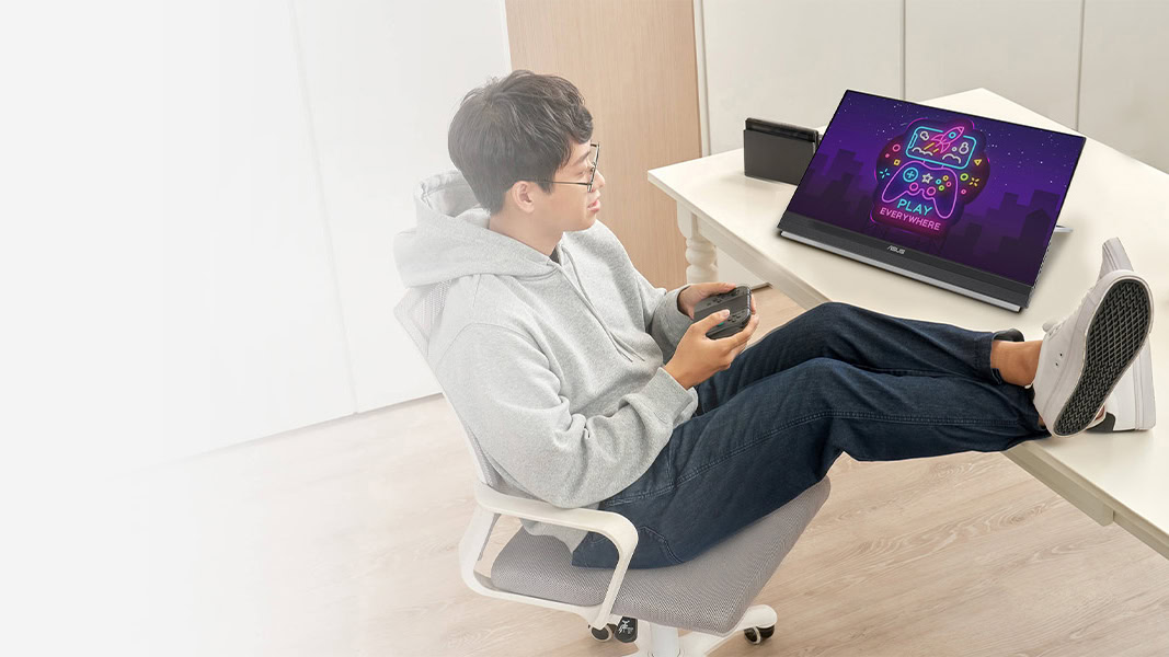 Homem jogando no monitor port&aacute;til ASUS ZenScreen de 22 polegadas