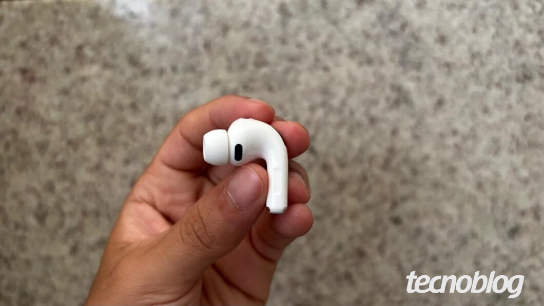 Uma m&atilde;o segurando um dos fones AirPods Pro 3 lateralmente