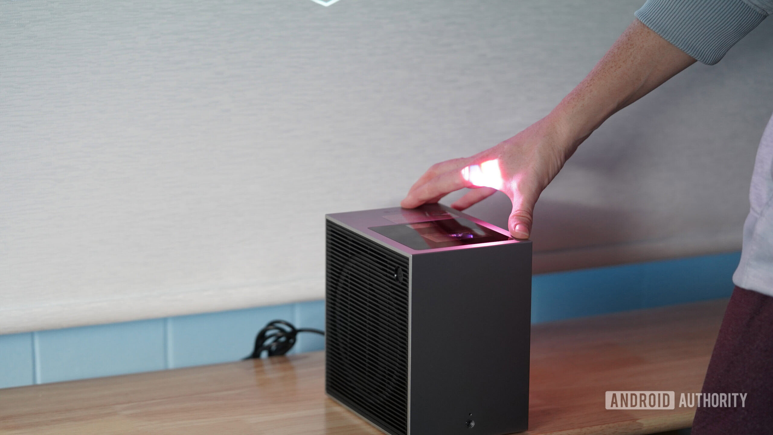 Portabilidade LG Cinebeam S Um usuário do LG Cinebeam S ajusta a distância de projeção.