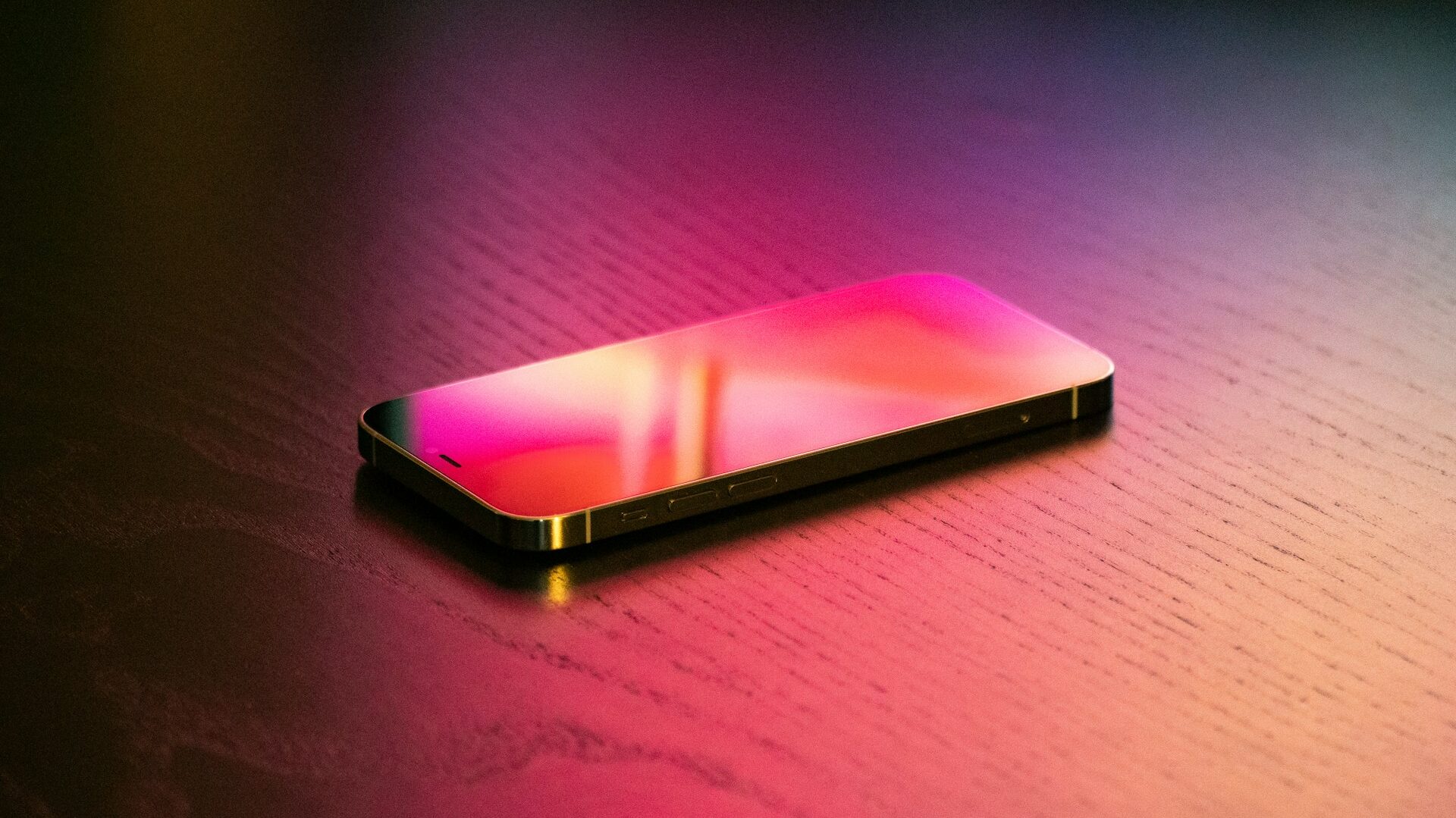 imagem de um celular em cima da mesa com reflxos em cores quentes