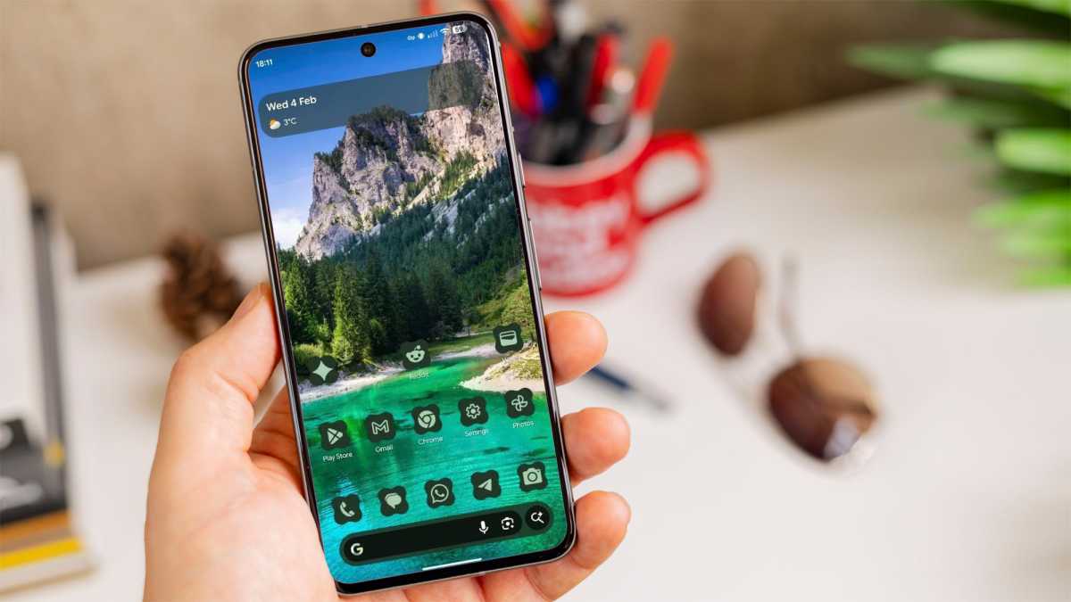 At A Glance widget with new contrast background on a Pixel phone in someone's hand