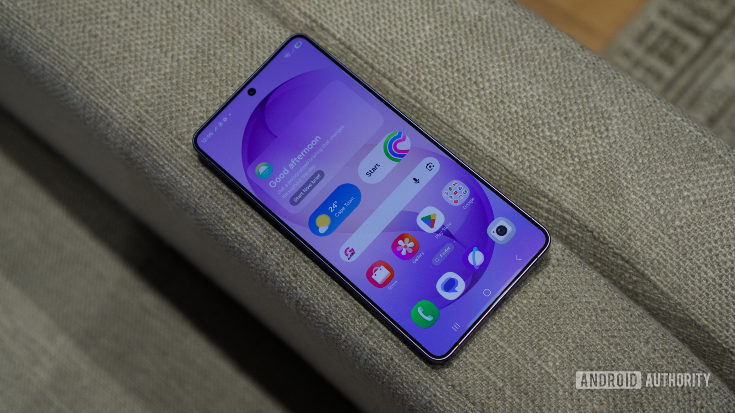 Tela do Samsung Galaxy S26 Ultra no sofá O Samsung Galaxy S26 Ultra, mostrando sua tela inicial.