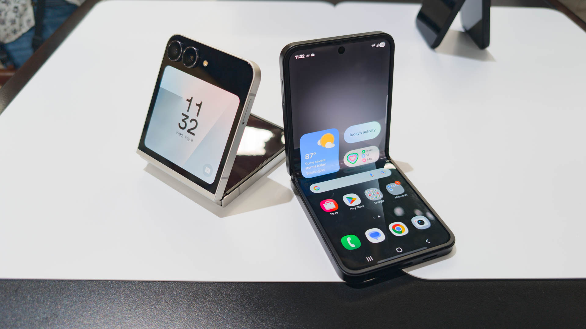 Samsung Galaxy Z Flip 7 FE nas cores preto e branco desdobrado parcialmente na mesa