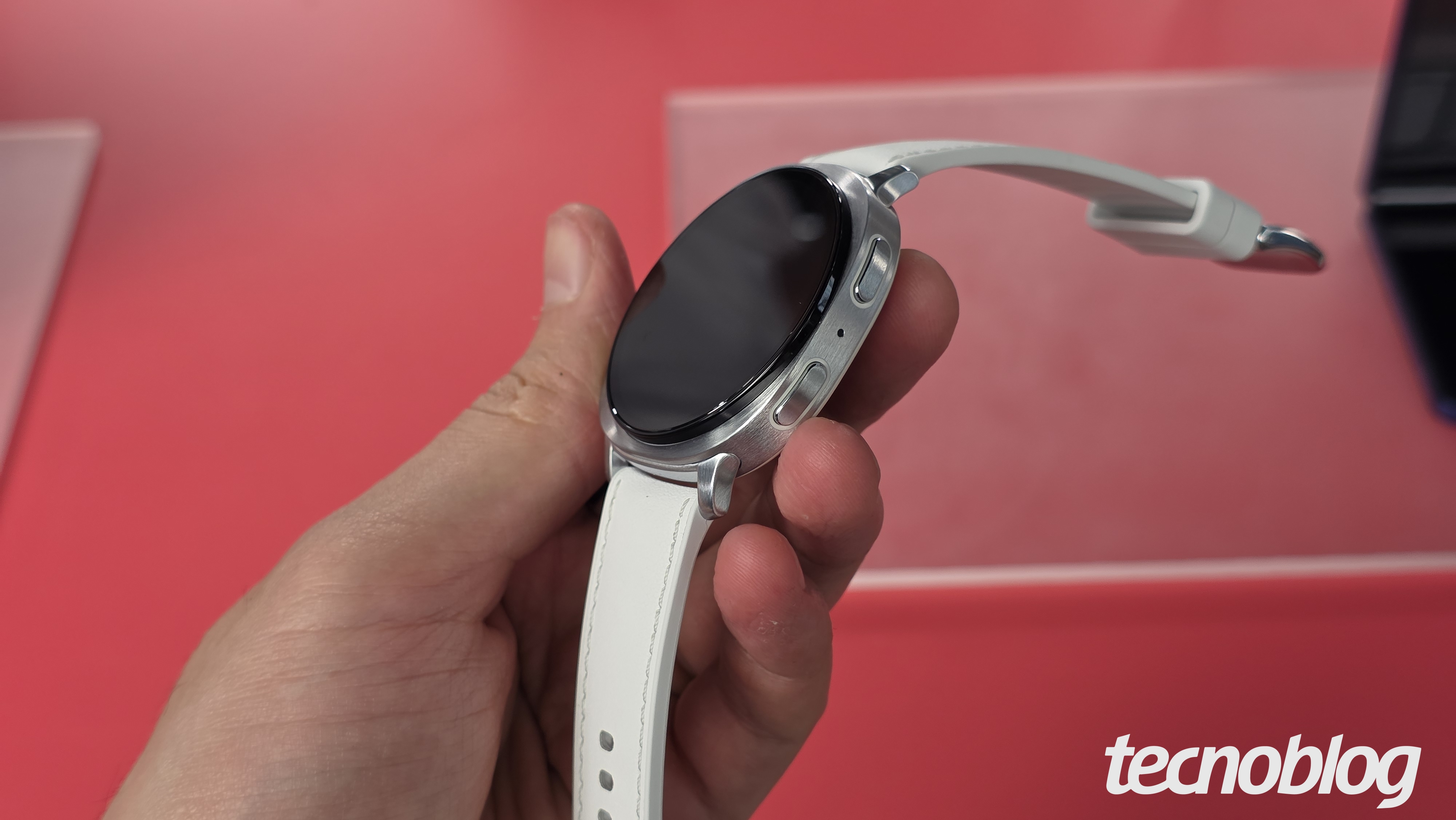 Mão segurando smartwatch com tela desligada