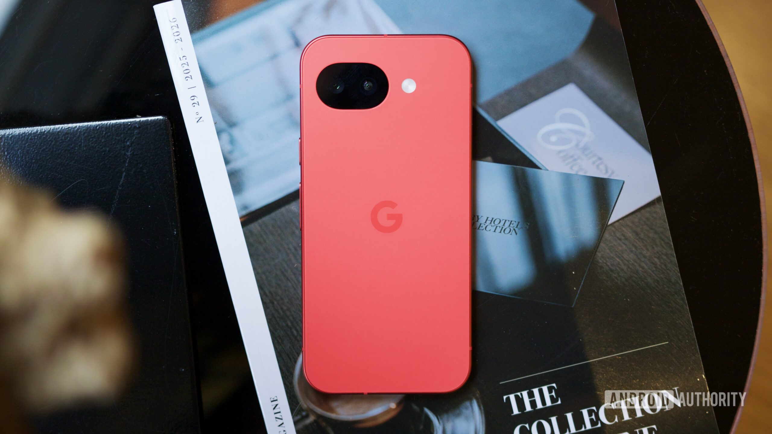 O Berry Google Pixel 10a deitado de bru&ccedil;os em uma mesa de centro.