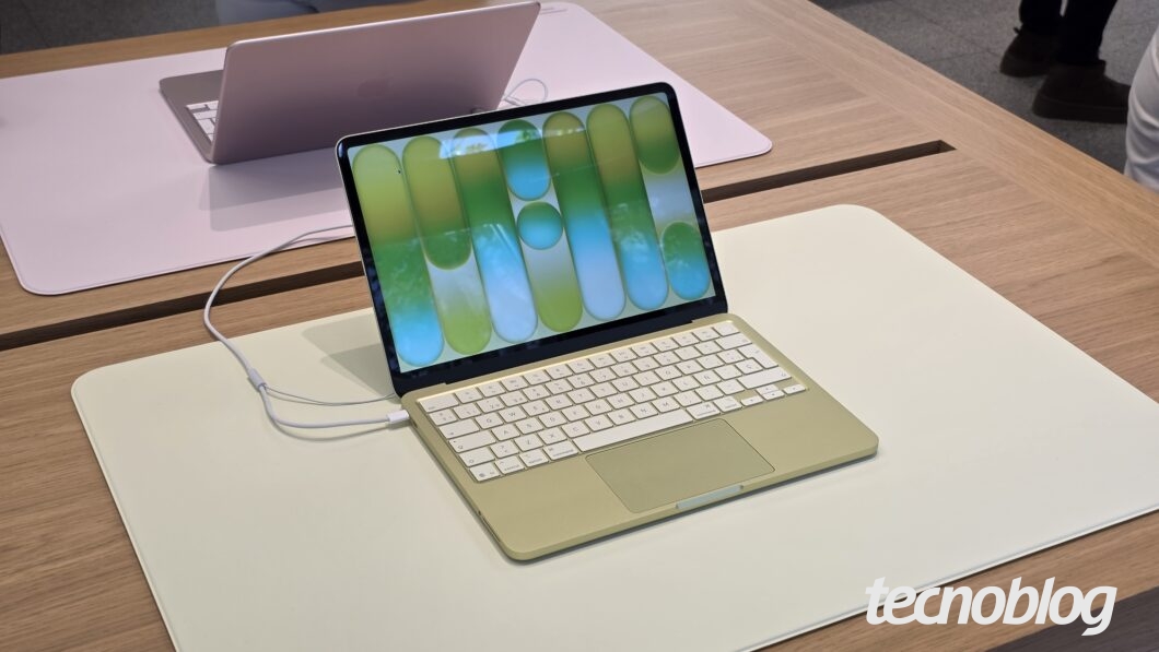 Fotografia colorida mostra um MacBook Neo de cor verde sobre uma bancada, em exposi&ccedil;&atilde;o.
