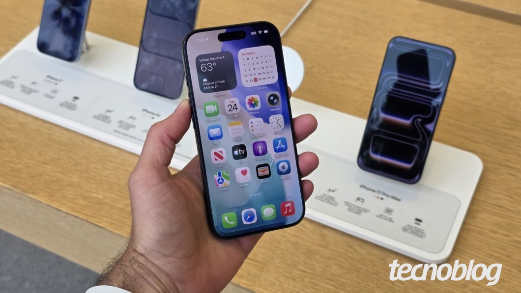Uma mão segurando o iPhone 17 Pro com a tela ligada na página inicial