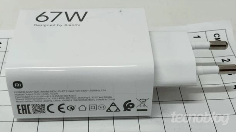 Imagem mostra um carregador branco, com a descri&ccedil;&atilde;o "67 W" desenhada na parte lateral