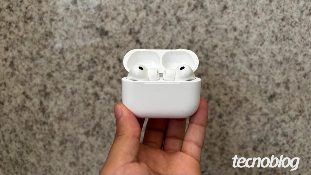 Uma m&atilde;o segurando o AirPods Pro 3 com o case aberto