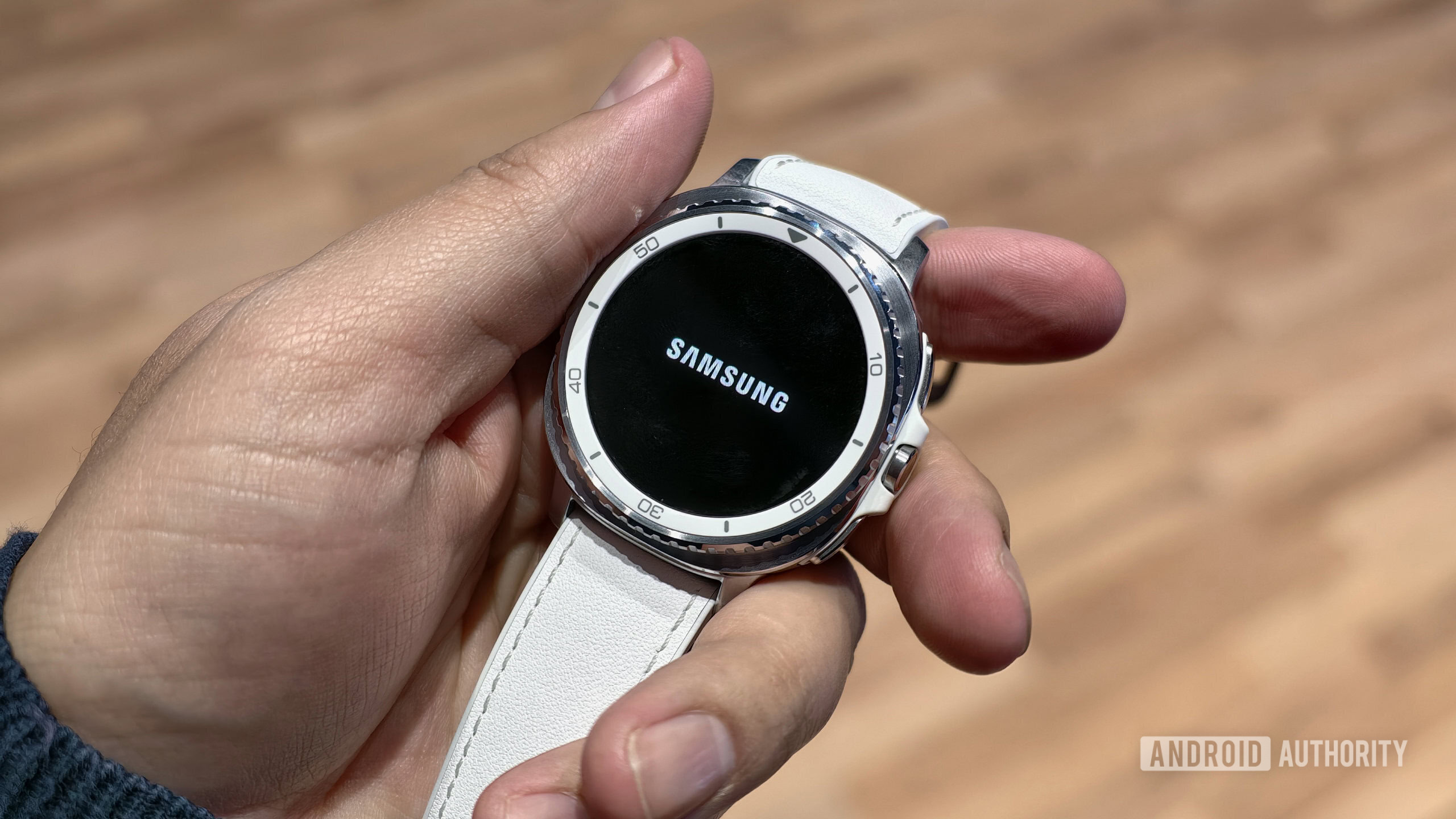 Samsung Galaxy Watch Classic em m&atilde;os com logotipo da Samsung