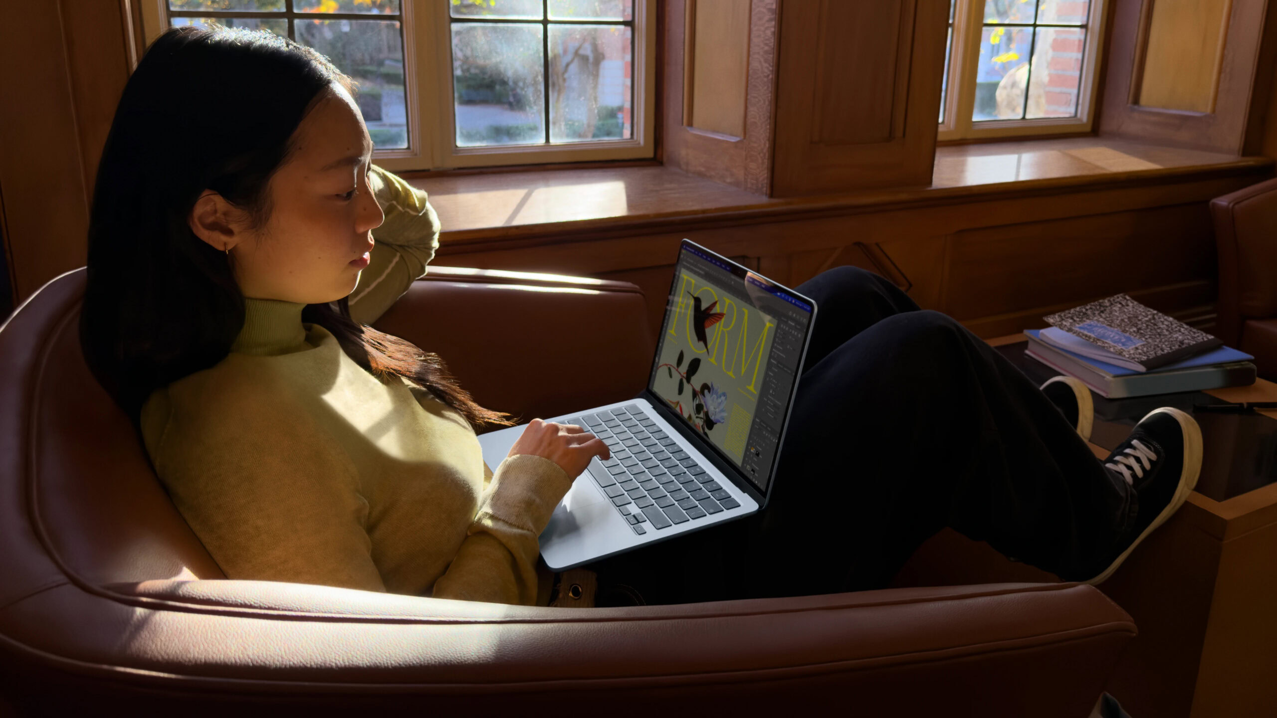 Mulher usando Apple MacBook Air M5 no sofá