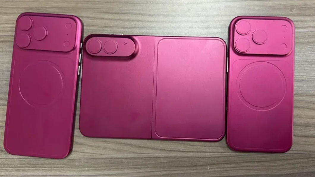 Foto de dummies em cor rosa de iphones em uma mesa.