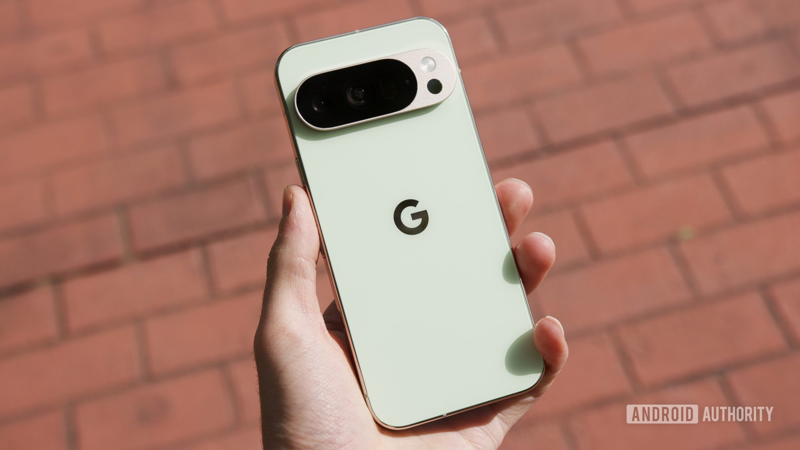 Alguém segurando o Google Pixel 10 Pro, com uma calçada de tijolos atrás dele.