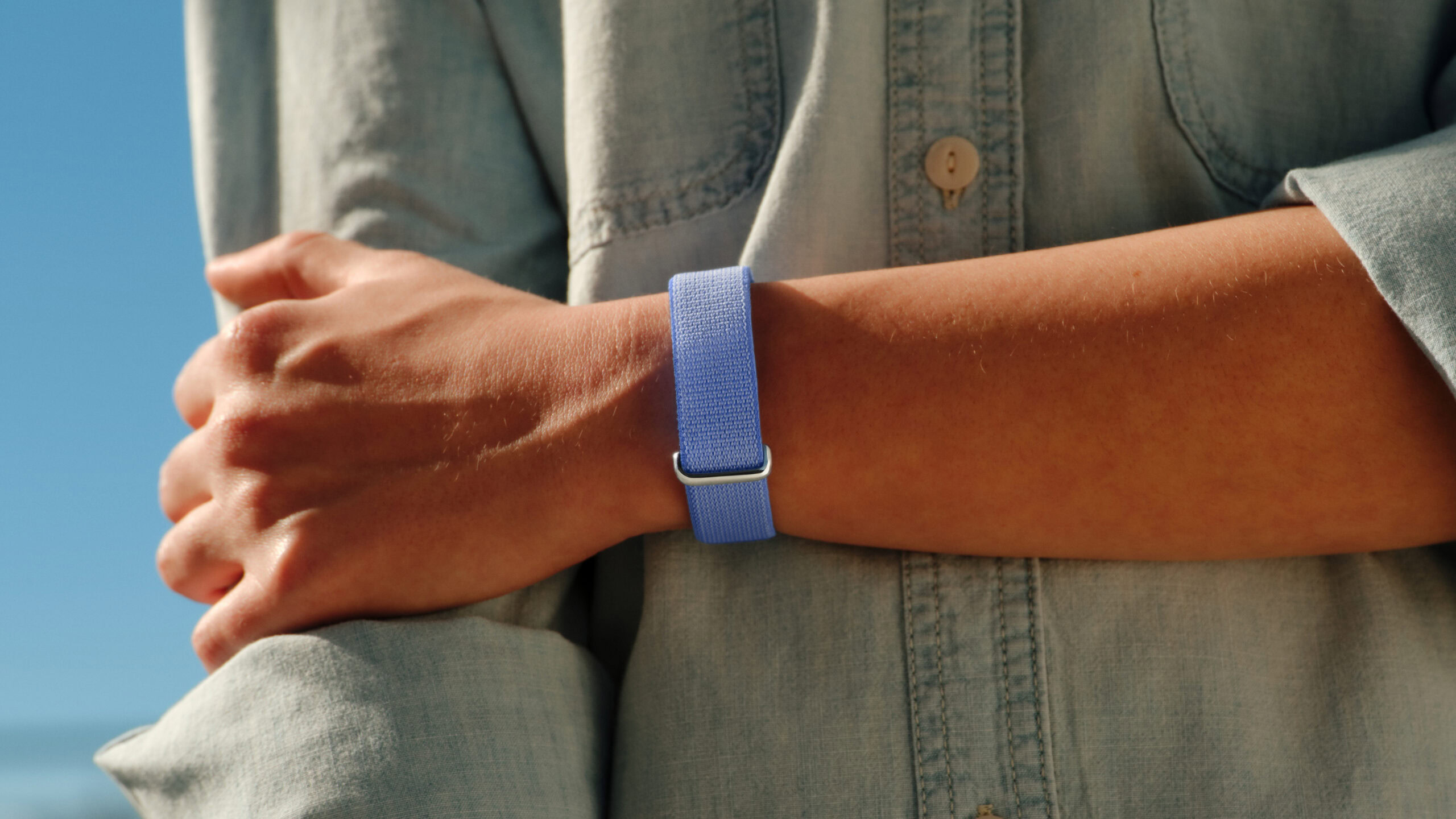 Uma foto do estilo de vida de alguém usando o Google Fitbit Air na cor lavanda.