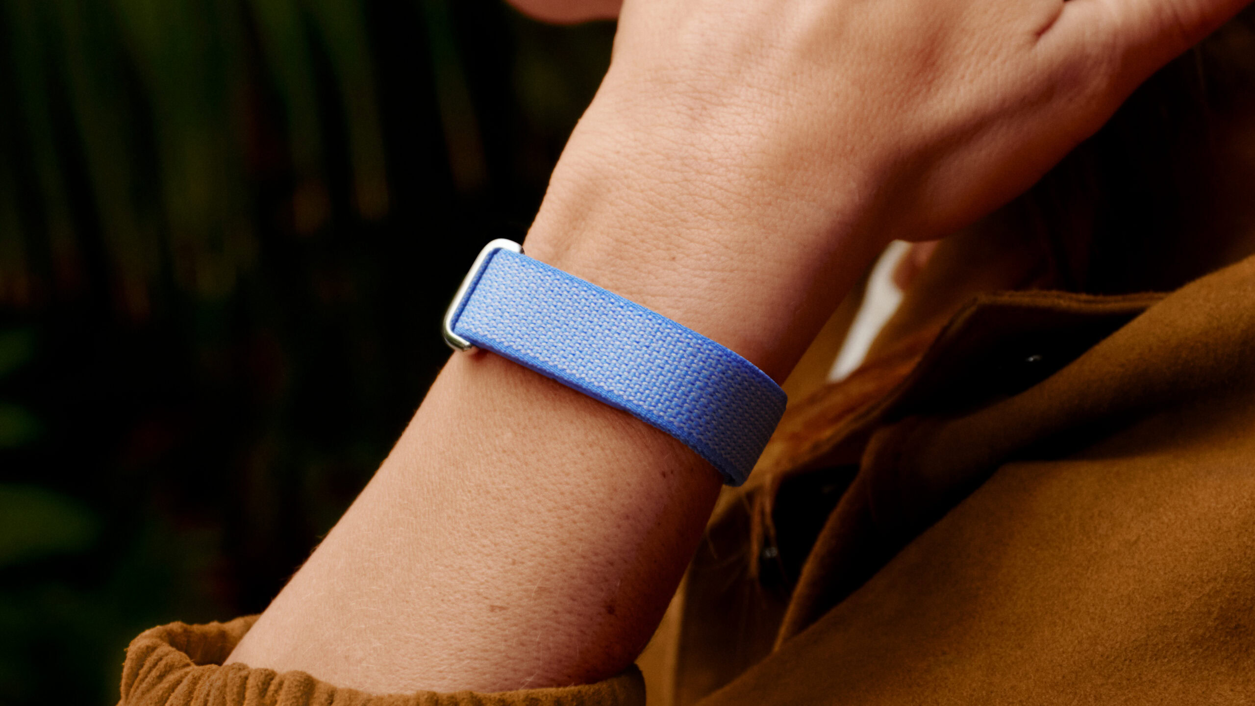 Uma foto do estilo de vida de alguém usando o Google Fitbit Air na cor lilás.
