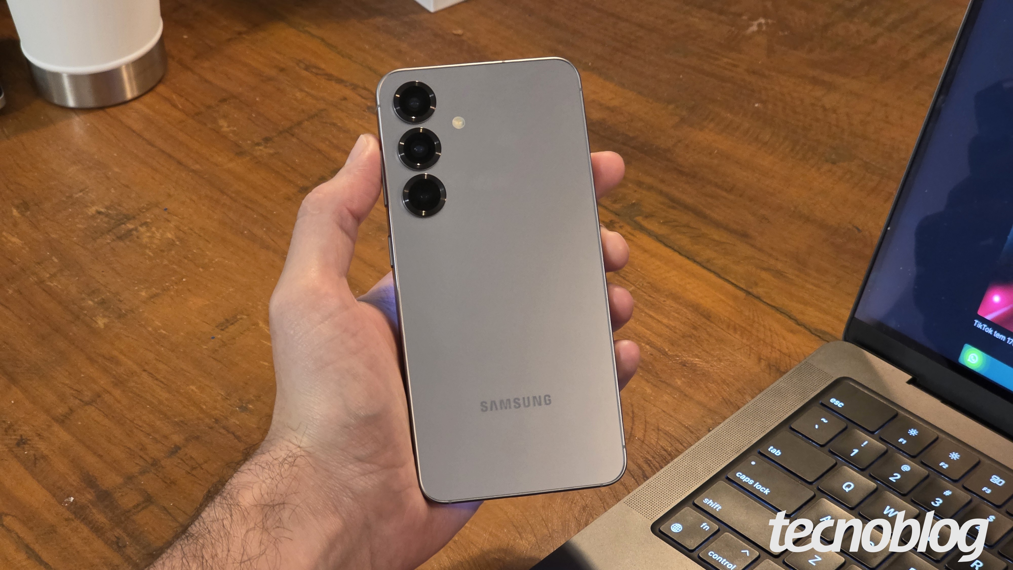 Mão segurando o Galaxy S25, mostrando a traseira com as câmeras