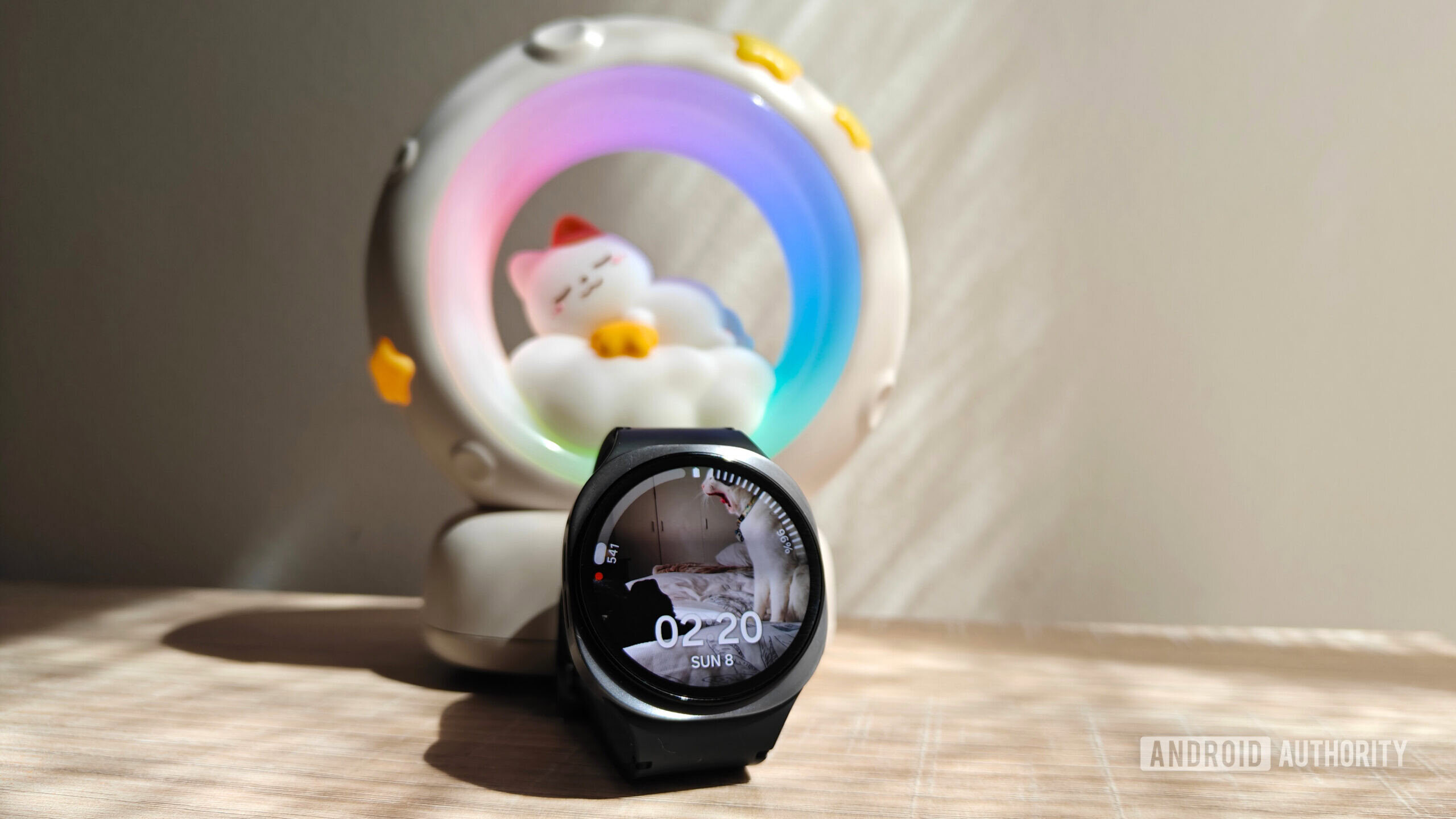 um Galaxy Watch 8 em frente a uma luz noturna com um gato dormindo na lua